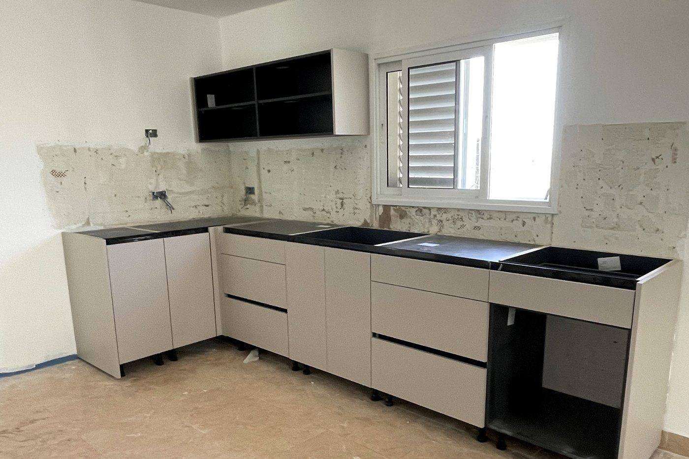 מטבח פינתי בהתקנה באותו בית – ארונות תחתונים ועליונים בגוון בז׳